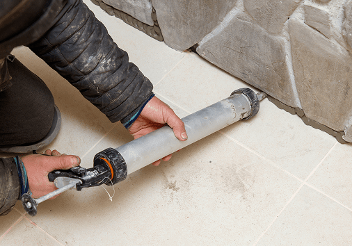 Worker using caulking tool for sealing